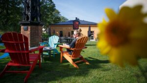 Person som sitter på färgglada stolar utomhus och solar