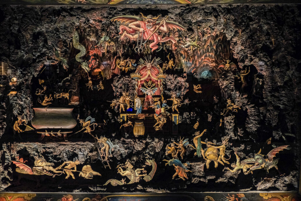 En bild på helvetesskåpet i en monter bestående av pappersfigurer av människor och varelser