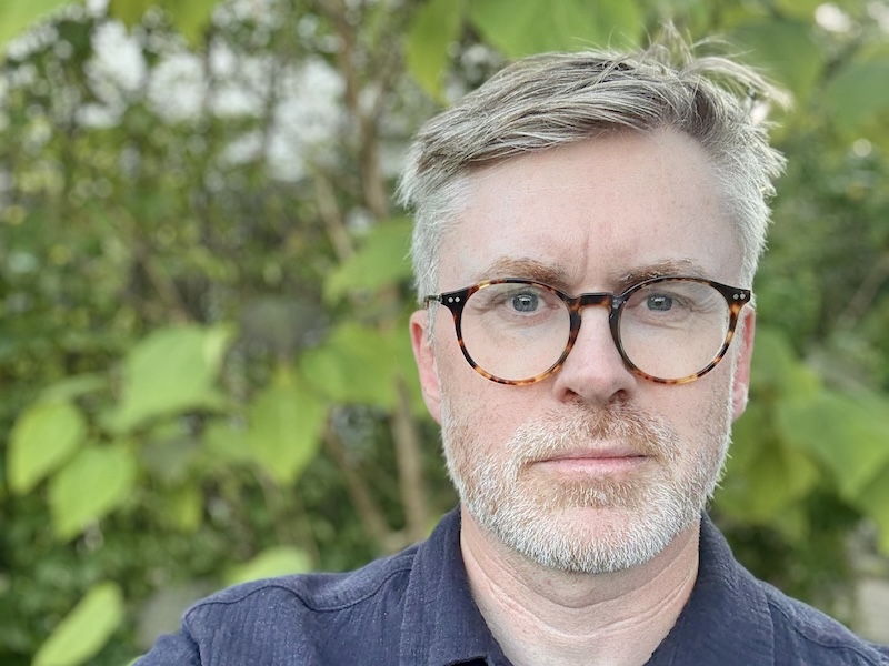 Bild på man i glasögon med ett träd bakom sig