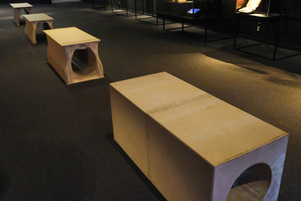 Rektangulära ljusa bänkar i trä som står på rad efter varandra och är ihåliga