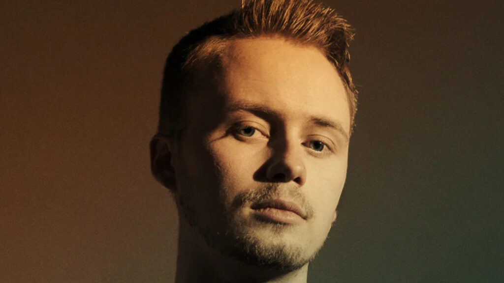 blond kille med neonljus som tittar in i kameran