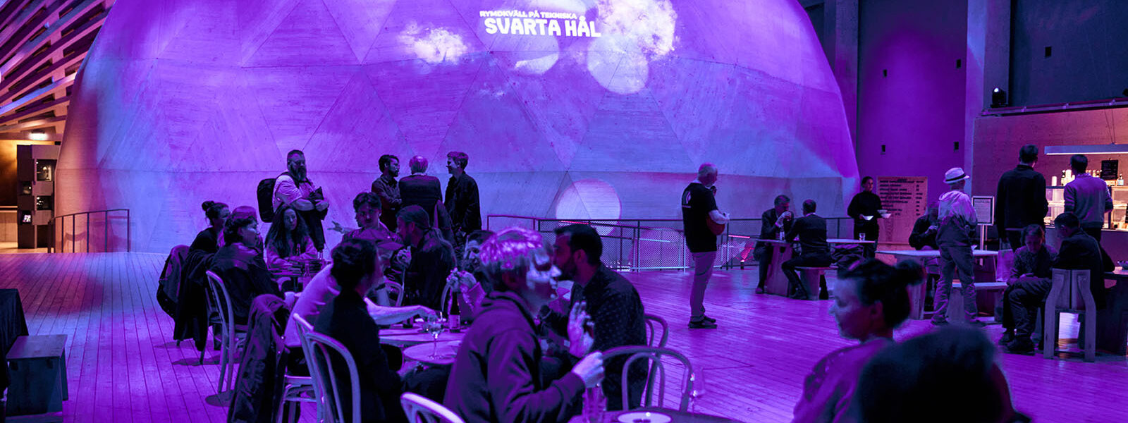 Mingel i trähallen under blått och neonljus