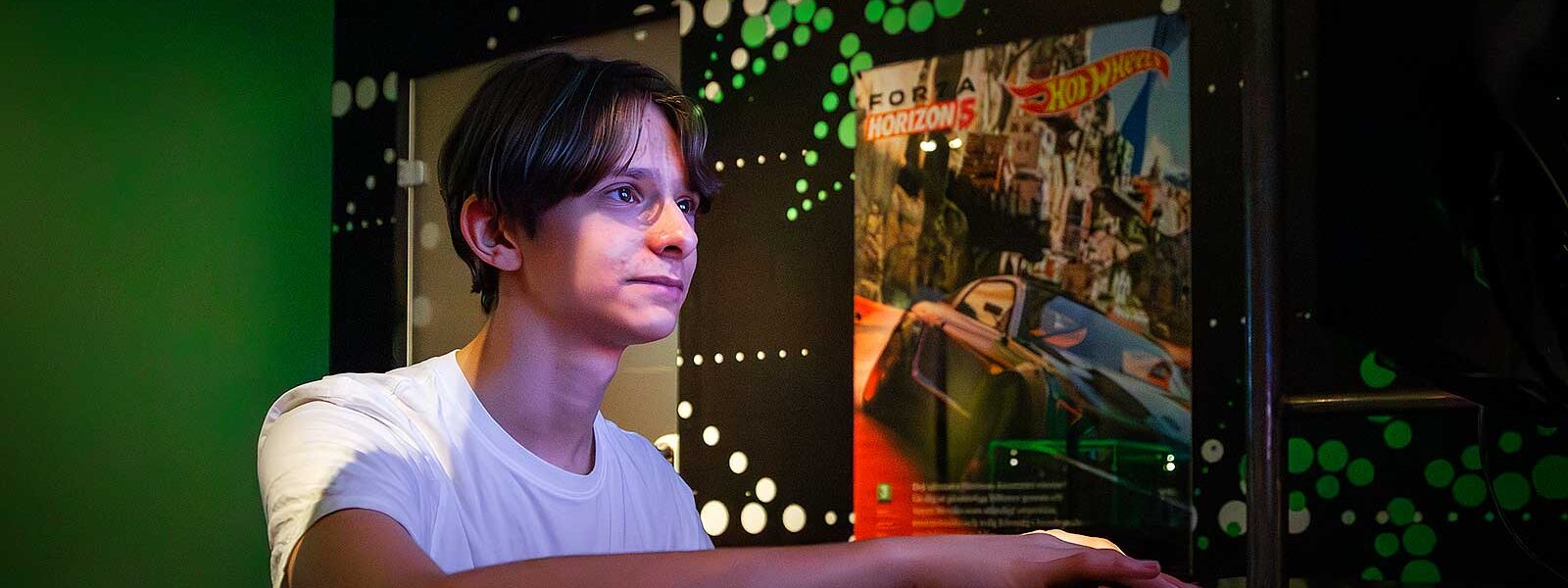 kille som står framför en skärm och spelar