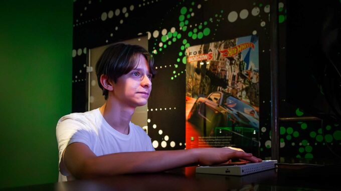 kille som står framför en skärm och spelar