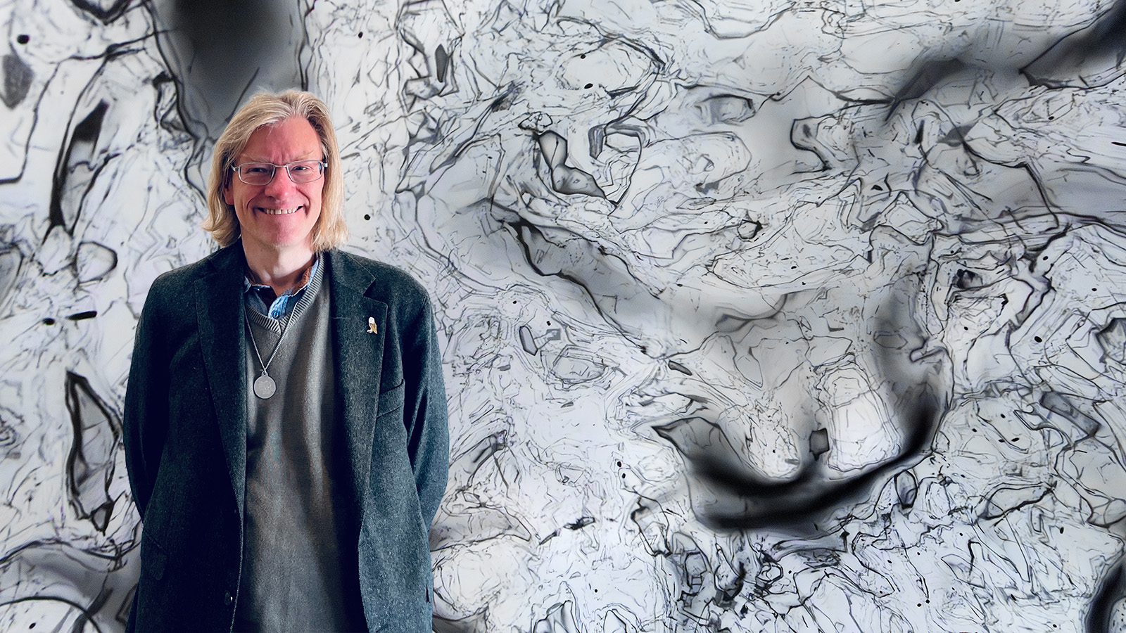 Man framför en rymdbakgrund och kläddd och kavaj