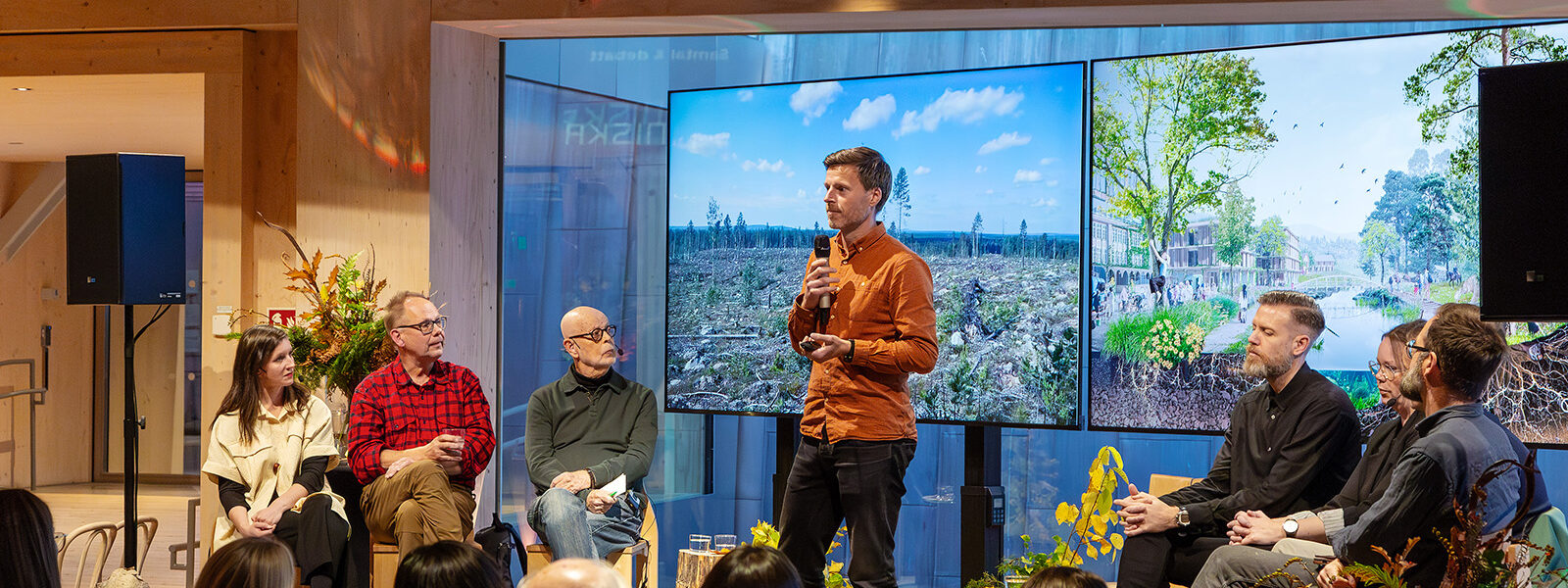 Man med mikrofon som pratar inför en publik