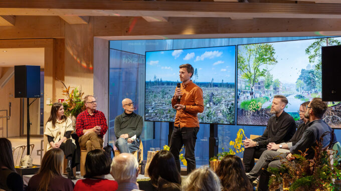 Man med mikrofon som pratar inför en publik