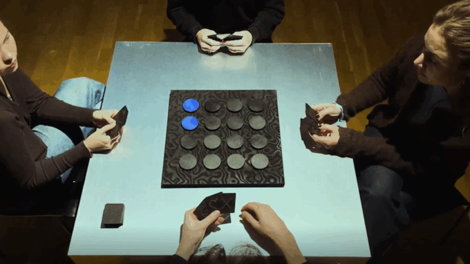 händer som spelar ett spel mot ett bord som är grönt