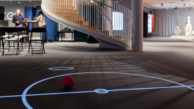 En spelplan, en boll och i bakgrunden syns The Cell spirala trappa till övervåningen.