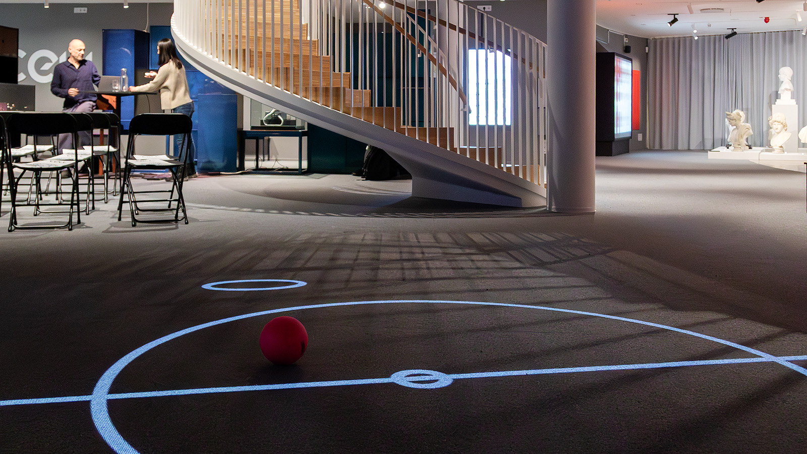 En spelplan, en boll och i bakgrunden syns The Cell spirala trappa till övervåningen.